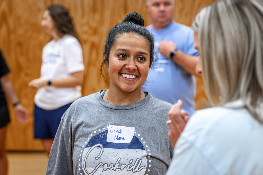female teacher smiling while talking to another teacher
