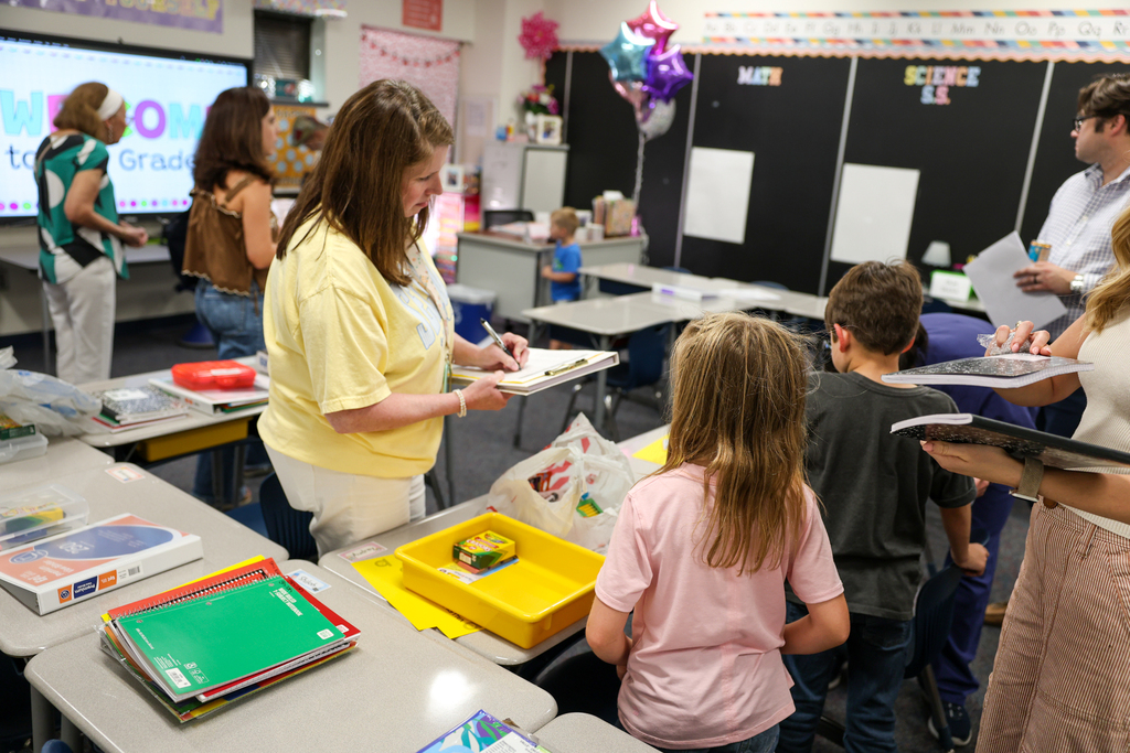a teacher helps a student at elementary meet the teacher