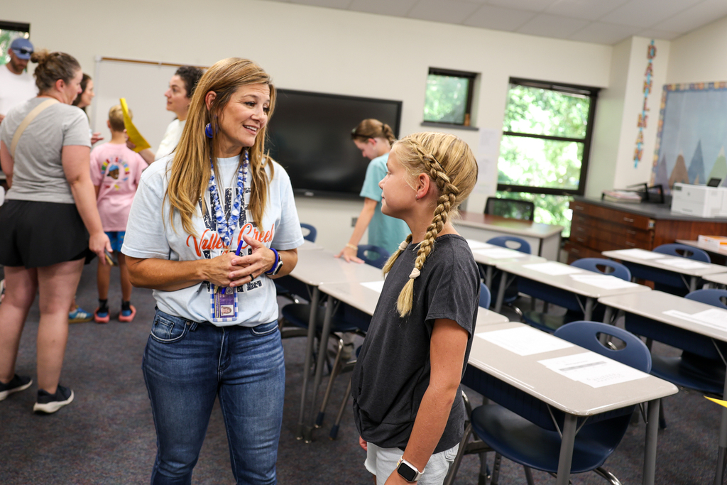 a teacher talks to a student at meet the teacher