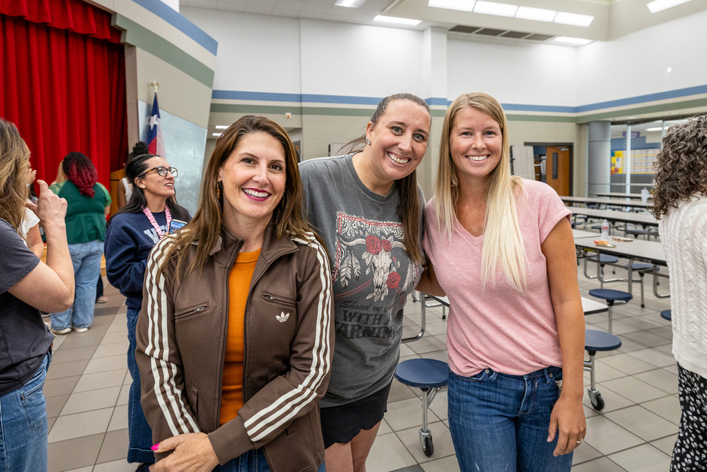 three teachers in line for lunch smiling for camera