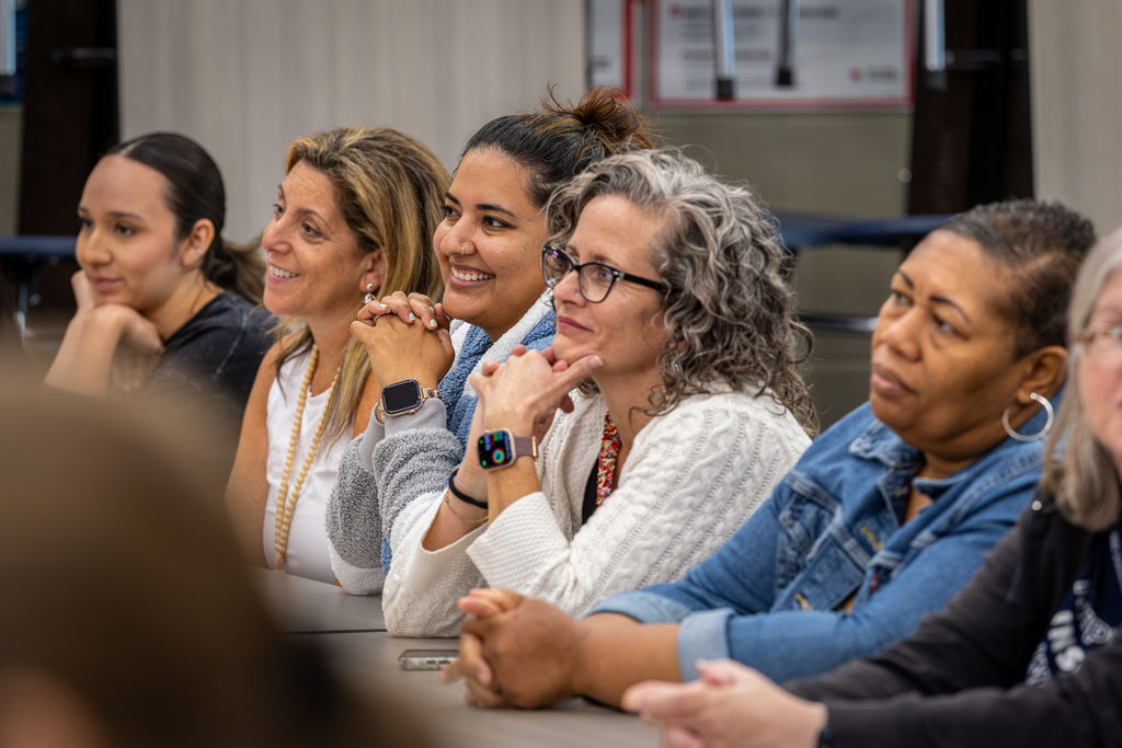 teachers sitting in a row and listening and smiling