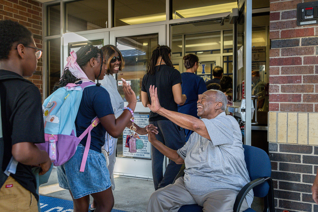 Jesse McGowen high fiving students and parents as they enter mcgowen elementary