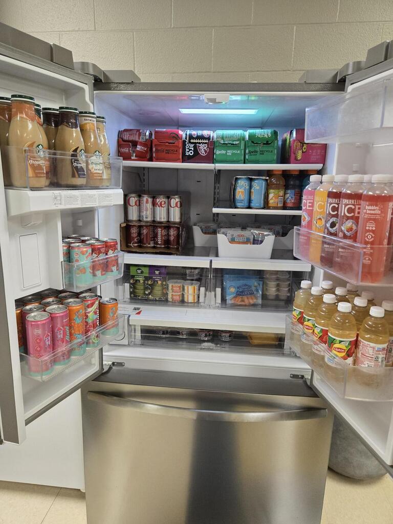 Picture of a fully stocked fridge with all types of drinks and snacks