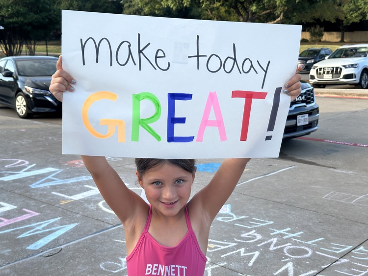 student holding sign “make today great"