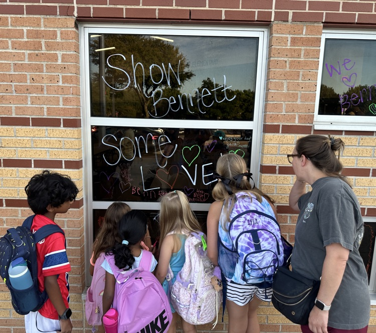 group of students writing positive messages on window
