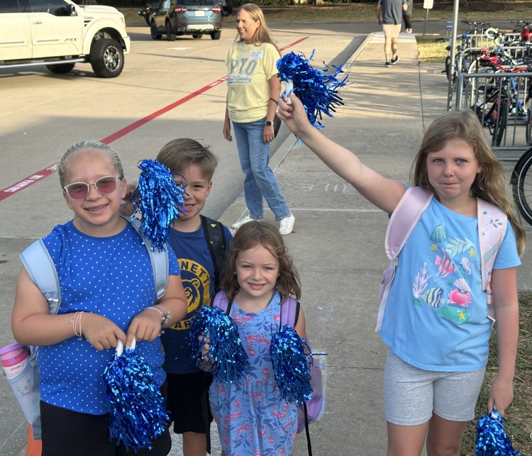 group of students cheering at the carpool drop off
