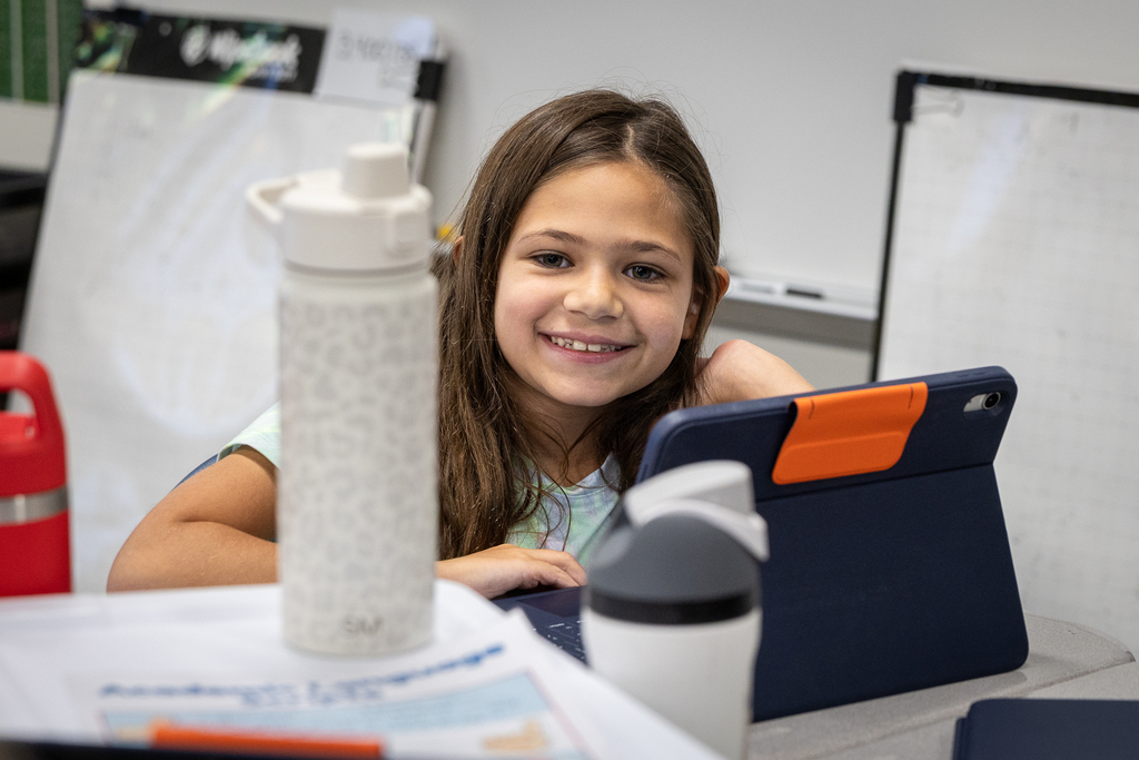 girl at desk smiling at camera