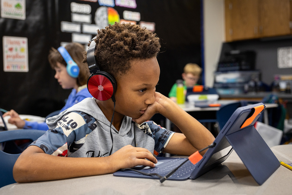 boy with headphones working on computer