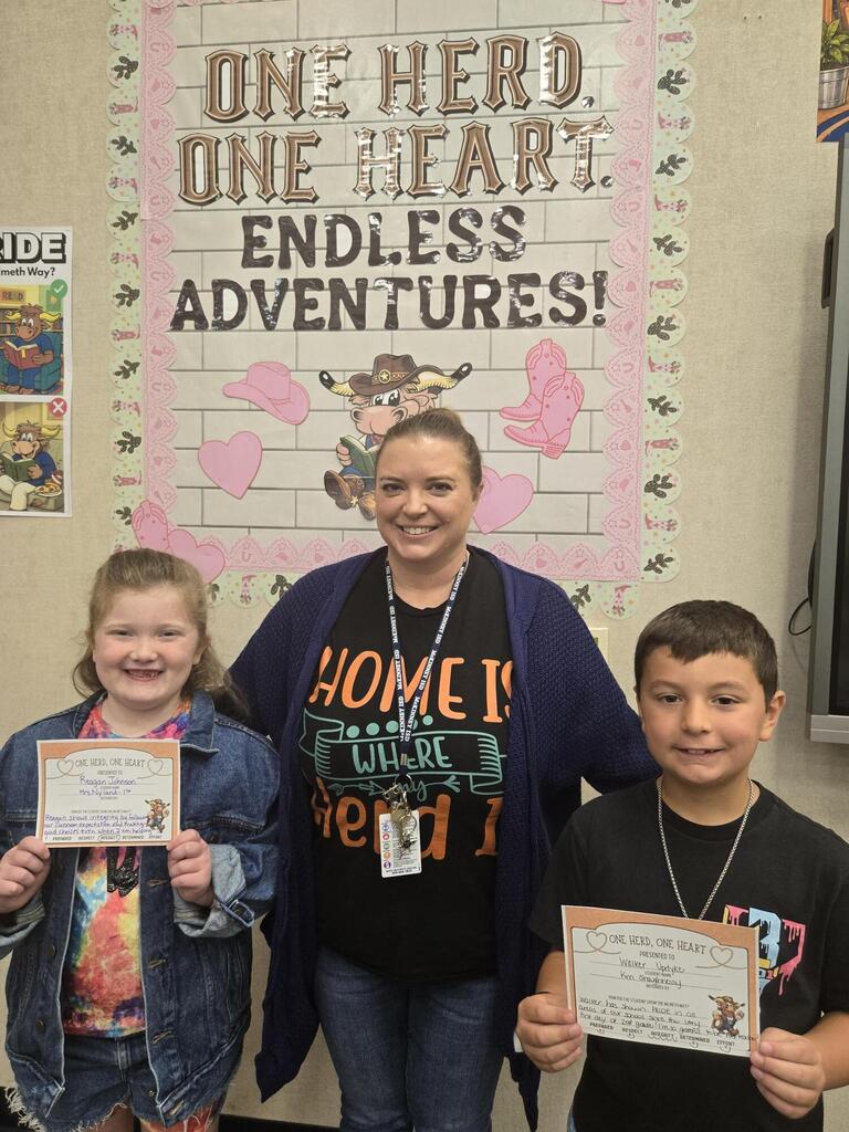Ms. Biggers and two students holding awards