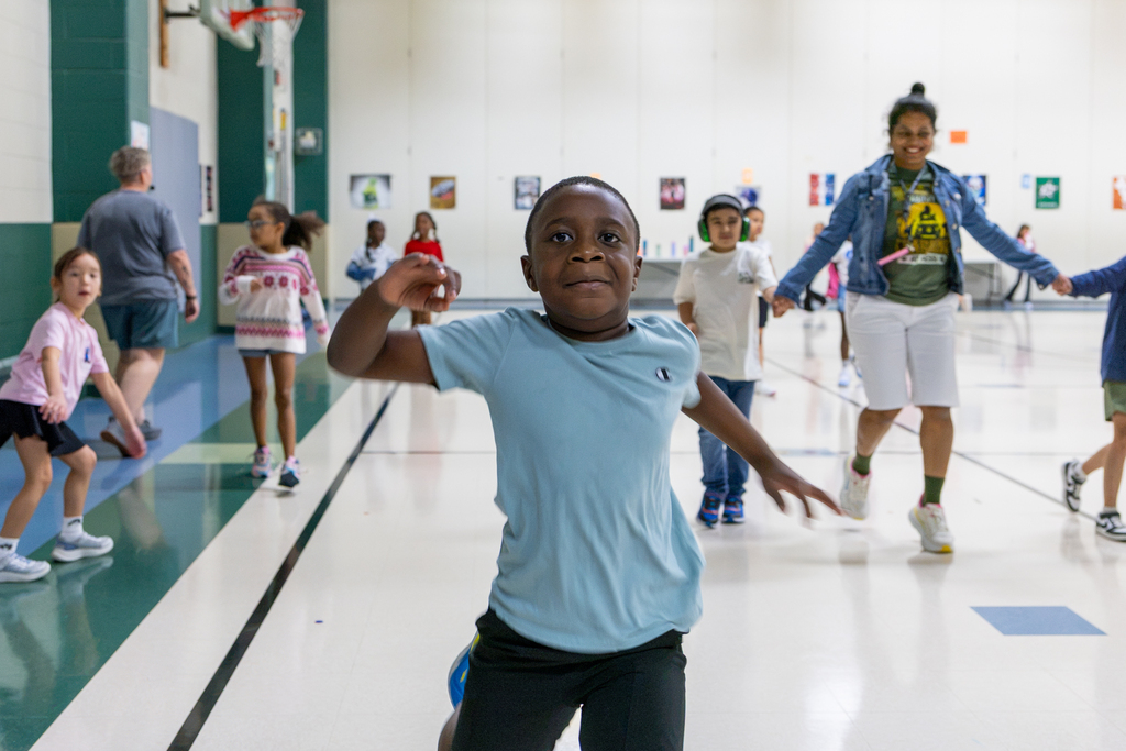 male student running toward camera in gym