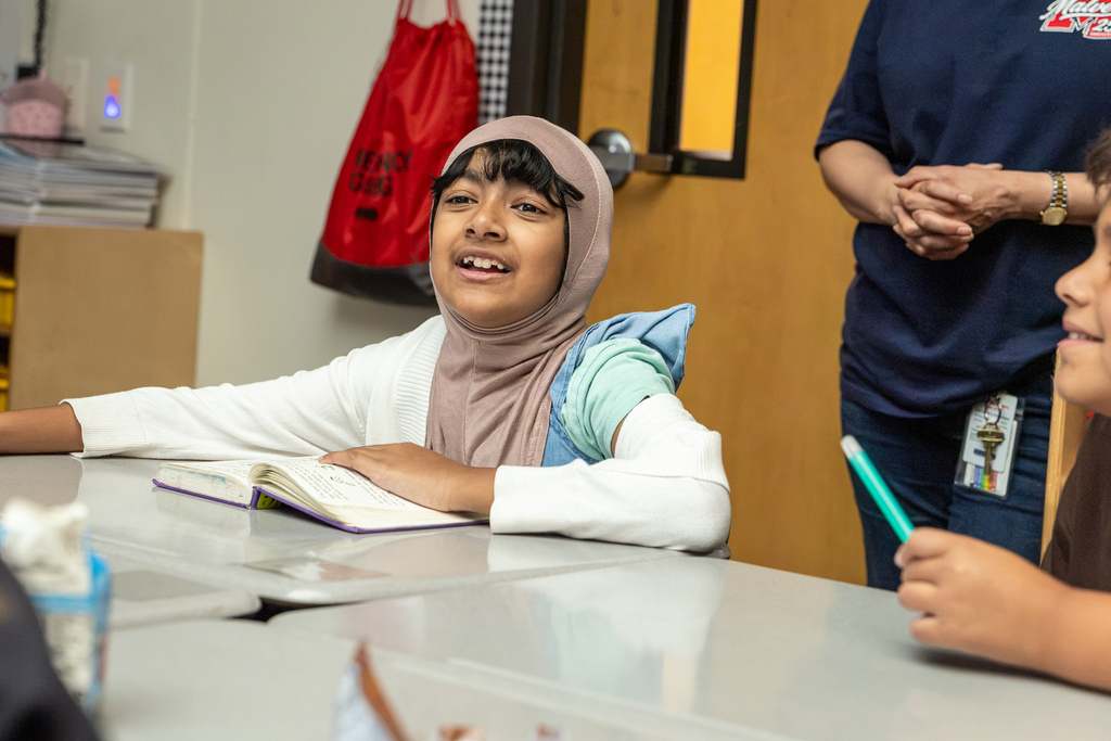 girl looking up from her book and smiling