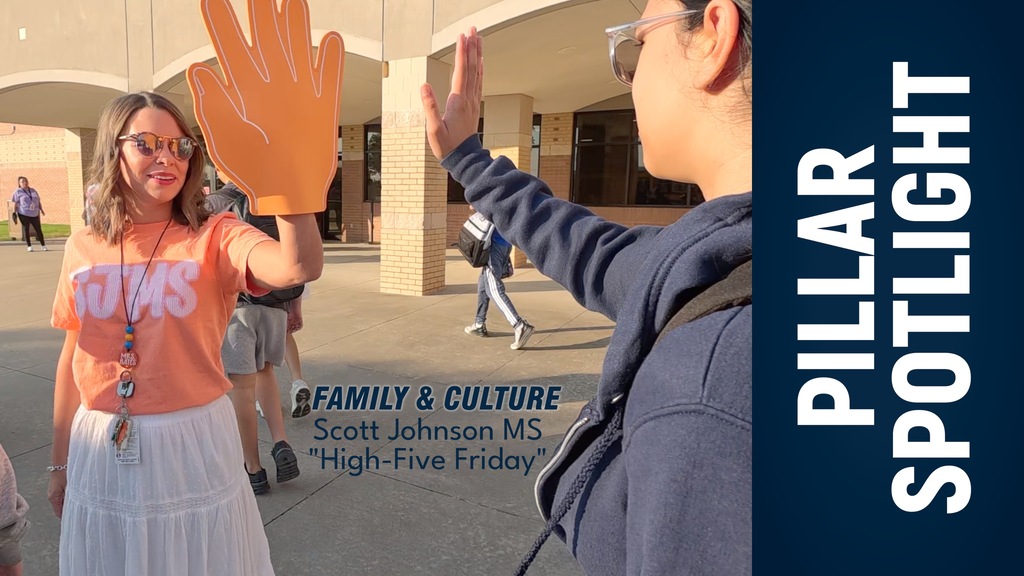 Staff and student at Scott Johnson Middle School exchange a high-five.