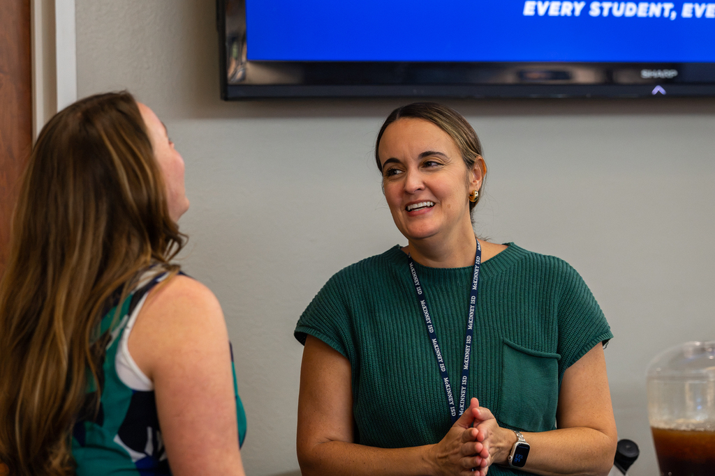 two women standing and talking and laughing
