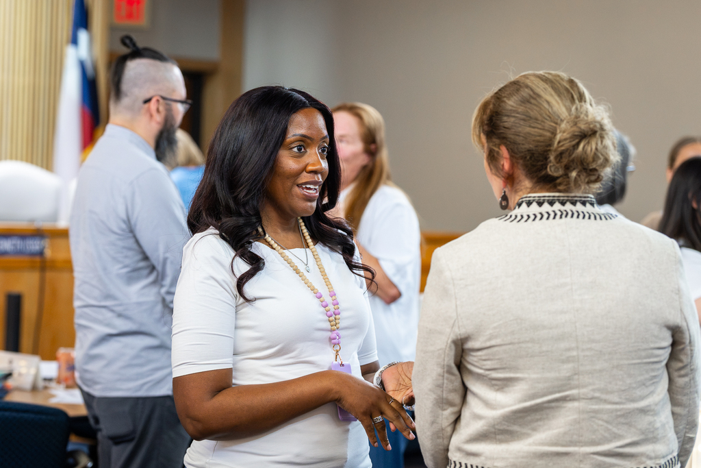 female participants standing and discussing a topic