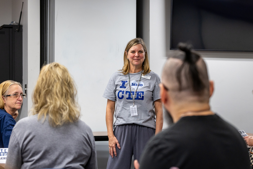 Jae Gaskill in front of group during debrief, smiling