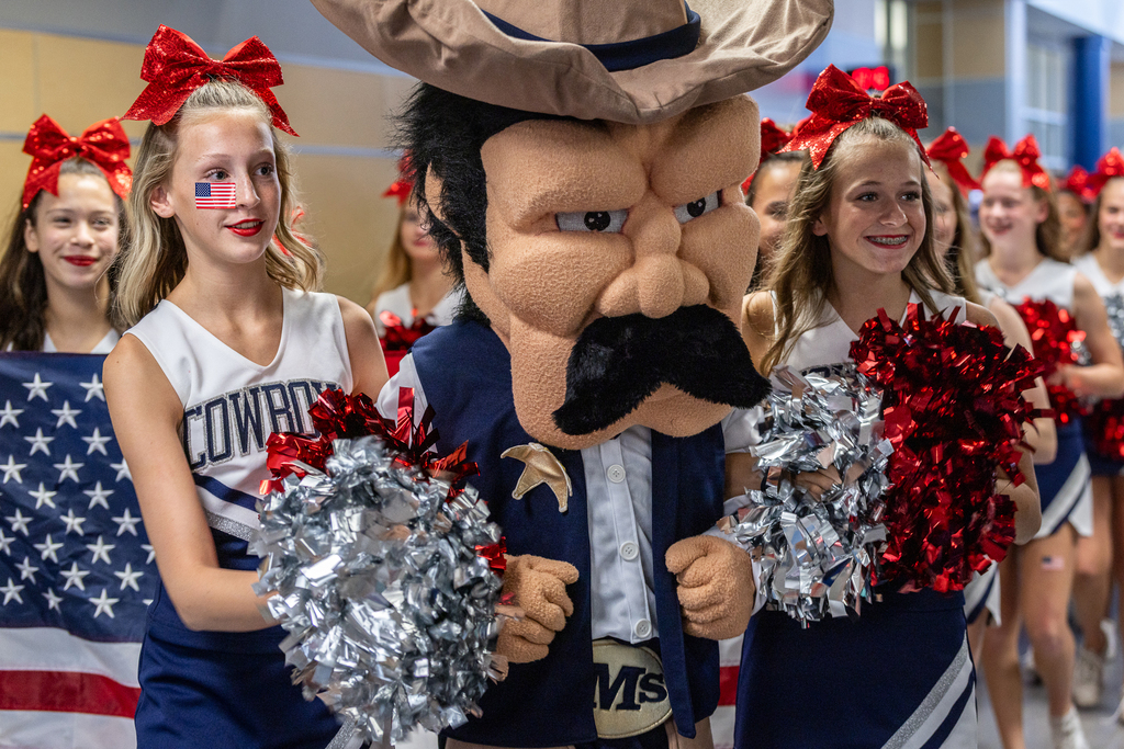cheerleaders and mascot walking at front of parade