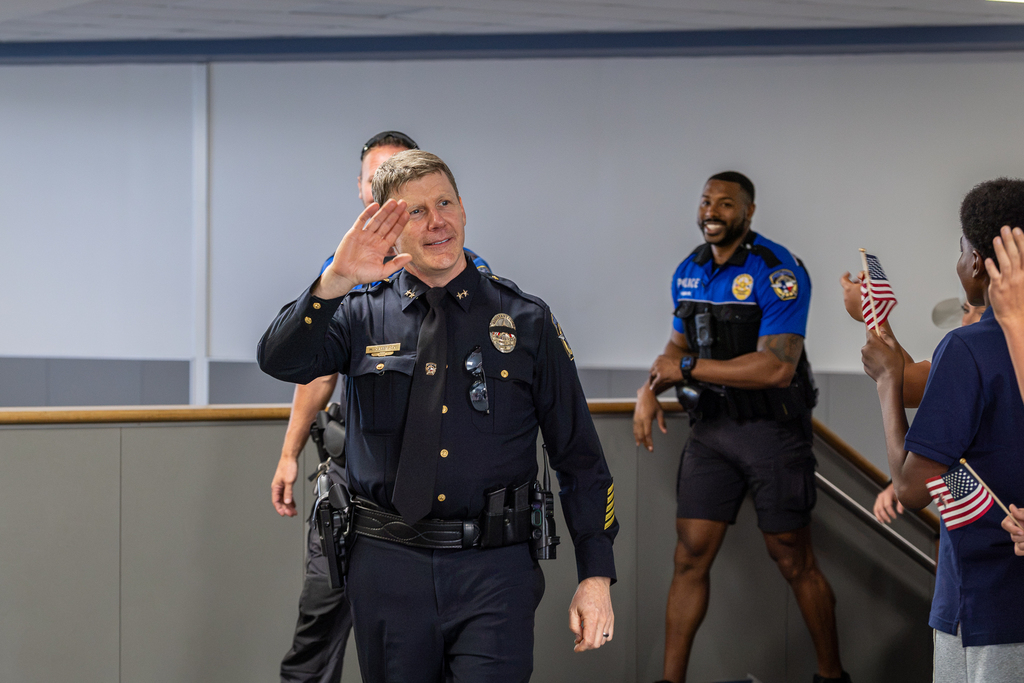 assistant police chief waving to kids