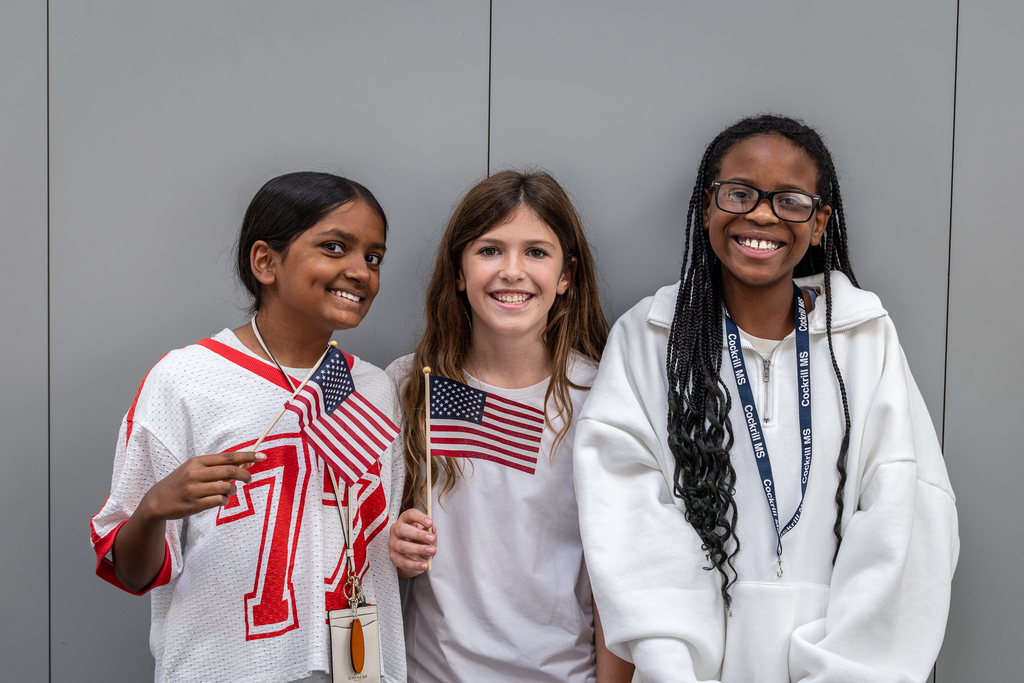 three girls smiling with American flags
