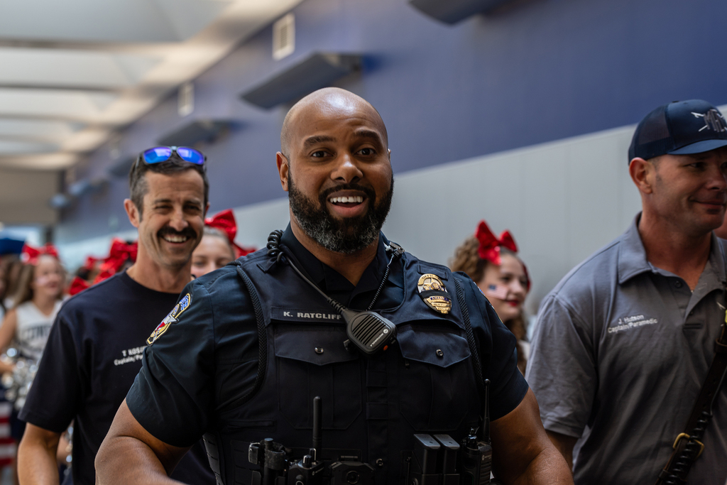 police officer smiling at camera and walking in parade