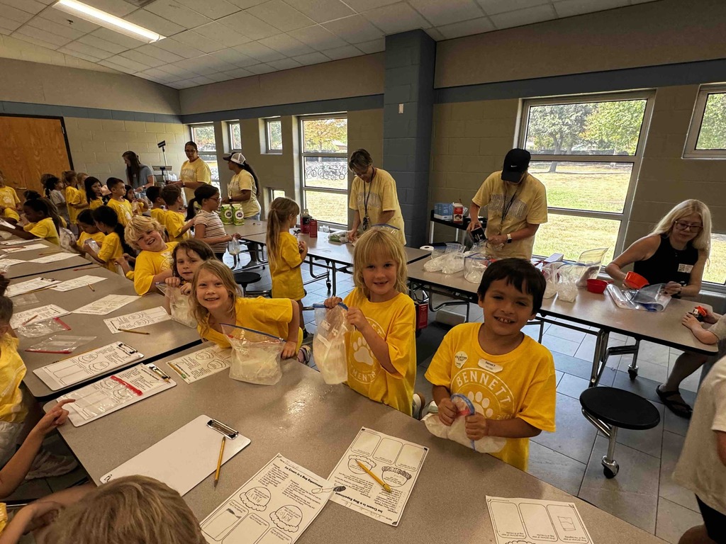 2nd graders at a table making ice cream and recording observations - exploring matter changes