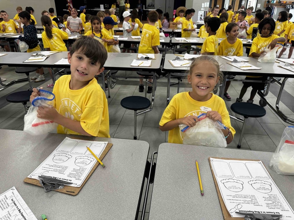 two students at a table making ice cream and recording notes- exploring matter changes