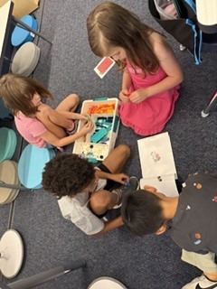 Group of 1st graders taking turns building their skateboard