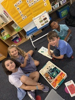 Group of 1st graders smiling at the camera with their lego kit