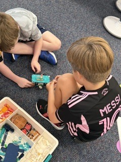 Two 1st graders testing their skateboard by turning on the "rocky road"