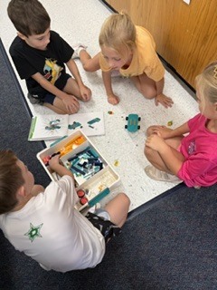 Group of 1st graders taking turns building their skateboard