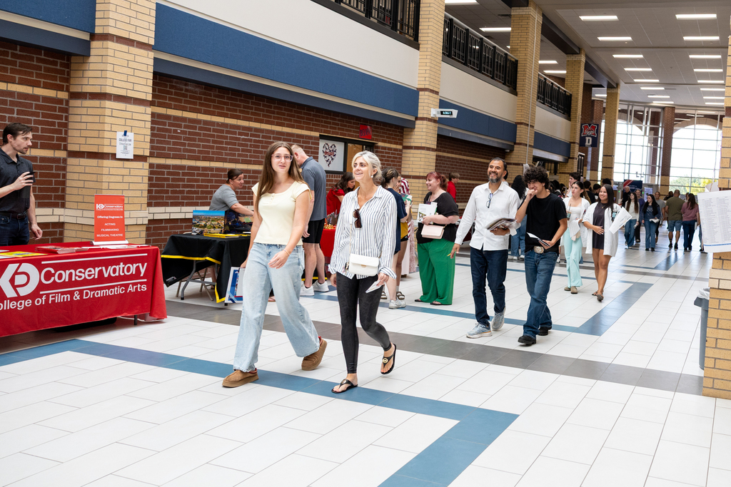 parents visit the tables at college night