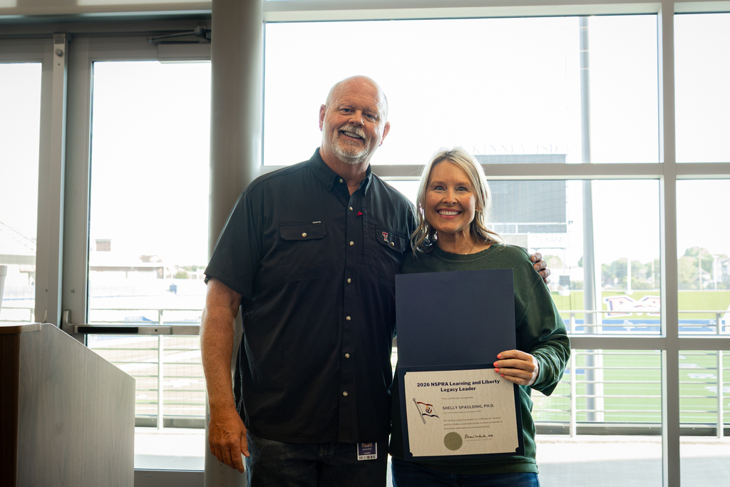 shawn pratt and shelly spaulding holding award certificate