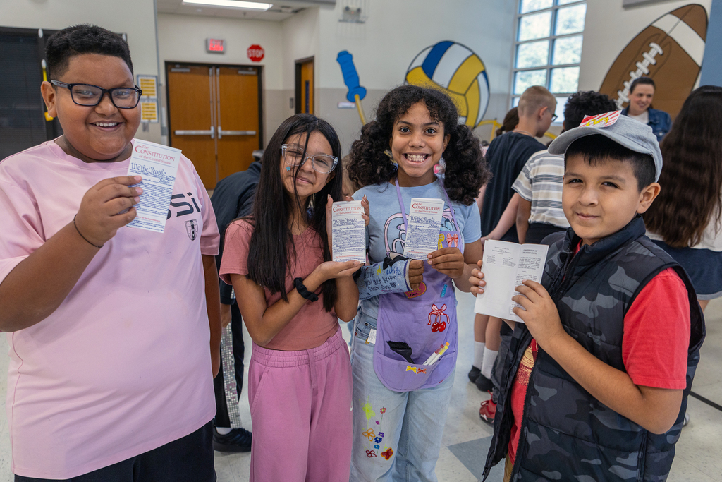 boys and girls smiling and holding up their copies of the declaration of independence