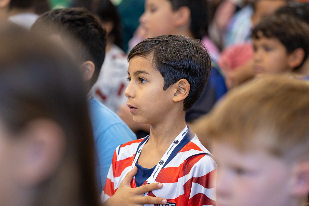 boy in audience with hand on heart during national anthem
