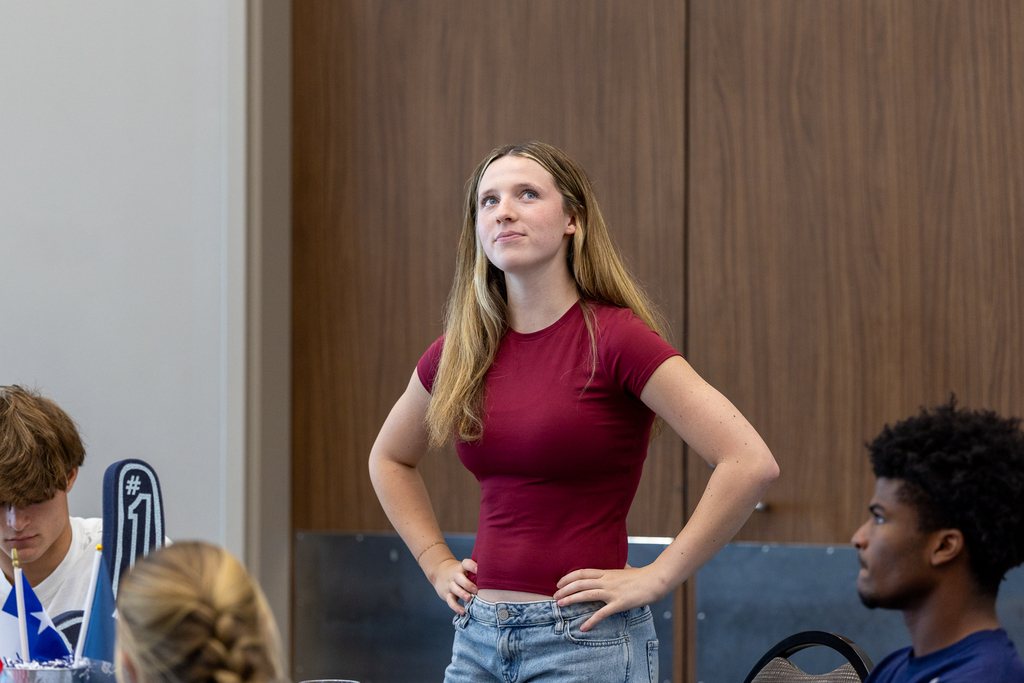 female student standing and looking up thoughtfully