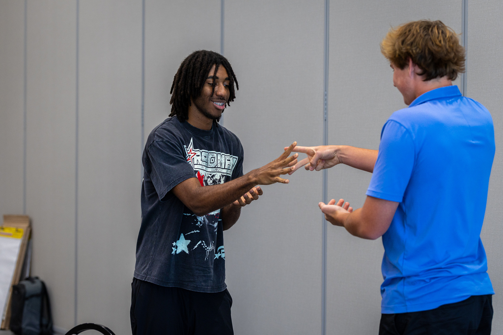 two male students playing rock, paper, scissors