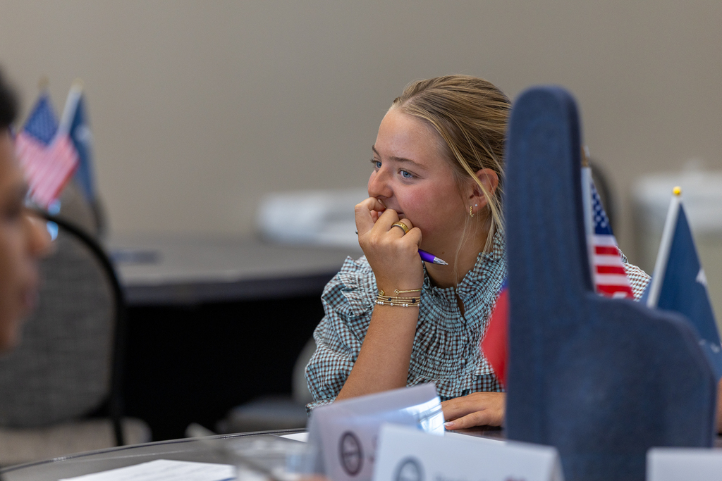 female student listening to another student at table