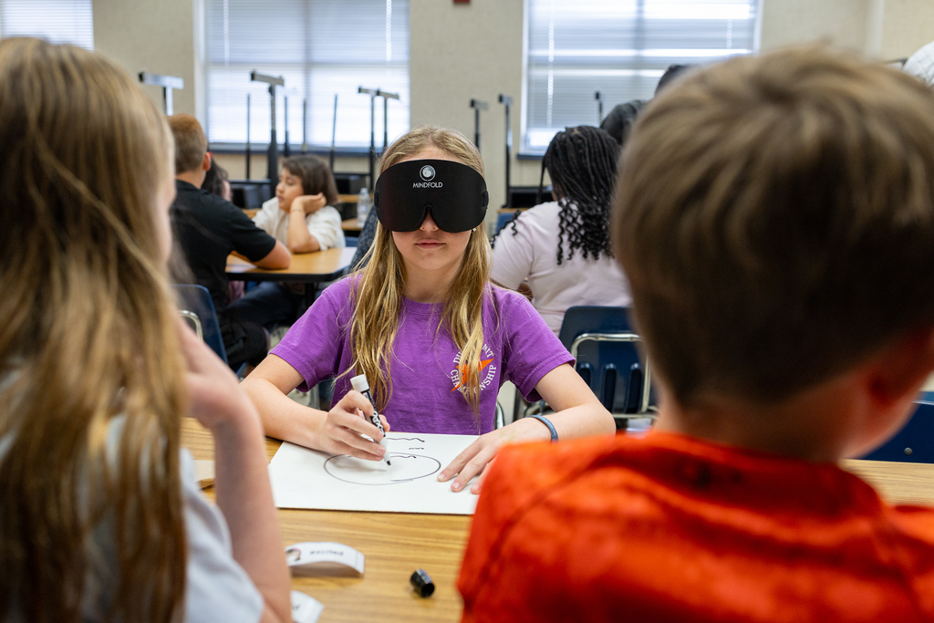 girl trying to draw while wearing a blindfold