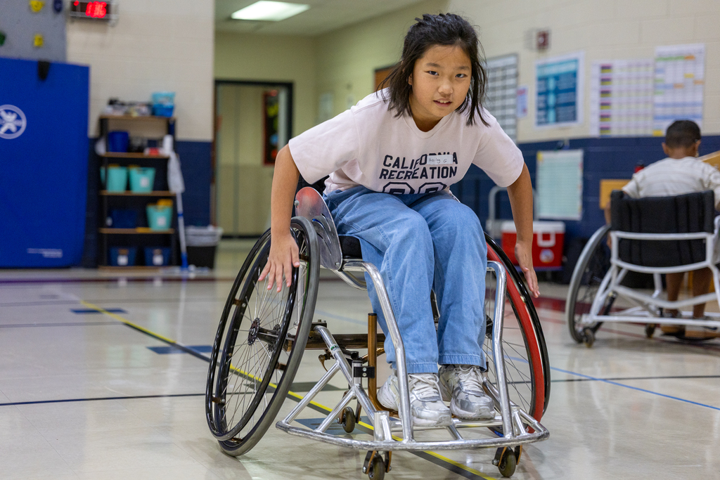 girl trying to maneuver in a wheelchair