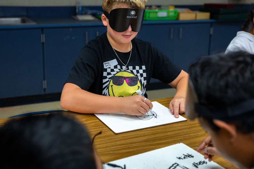boy trying to draw with a blindfold on