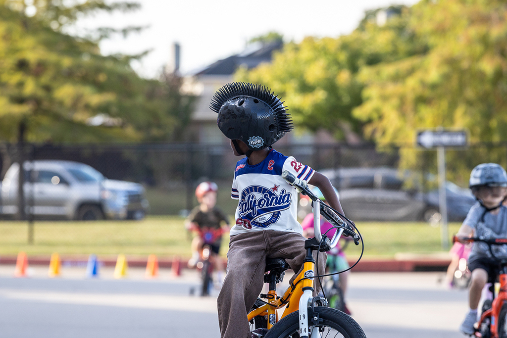 boy looking back over his shoulder while sitting on bike