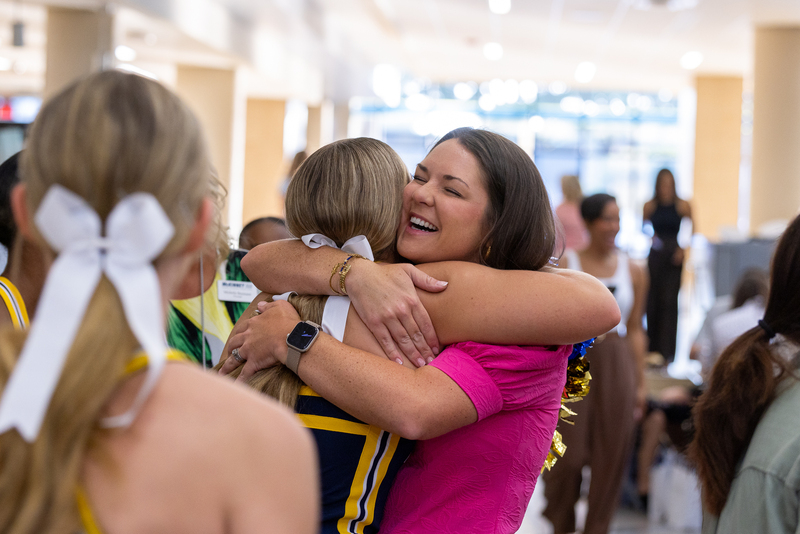 female teacher hugging cheerleader