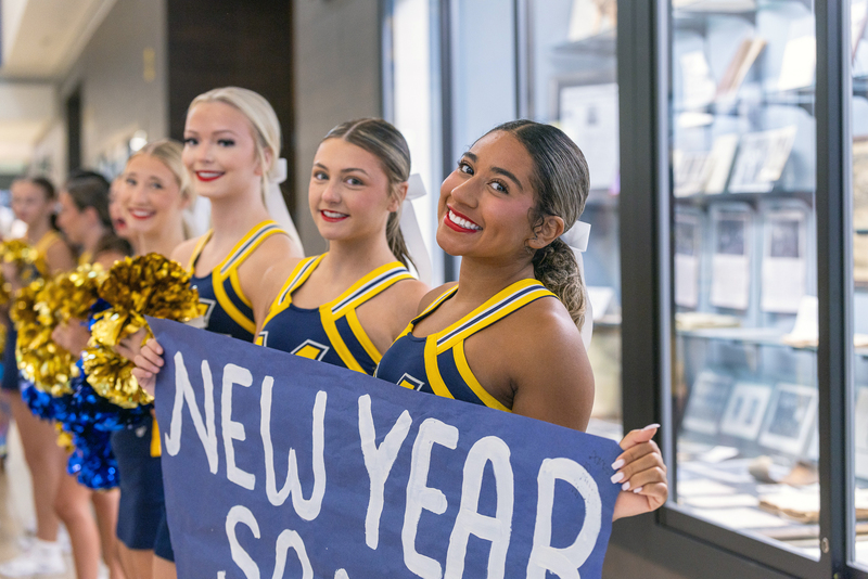 cheerleaders smiling and holding sign