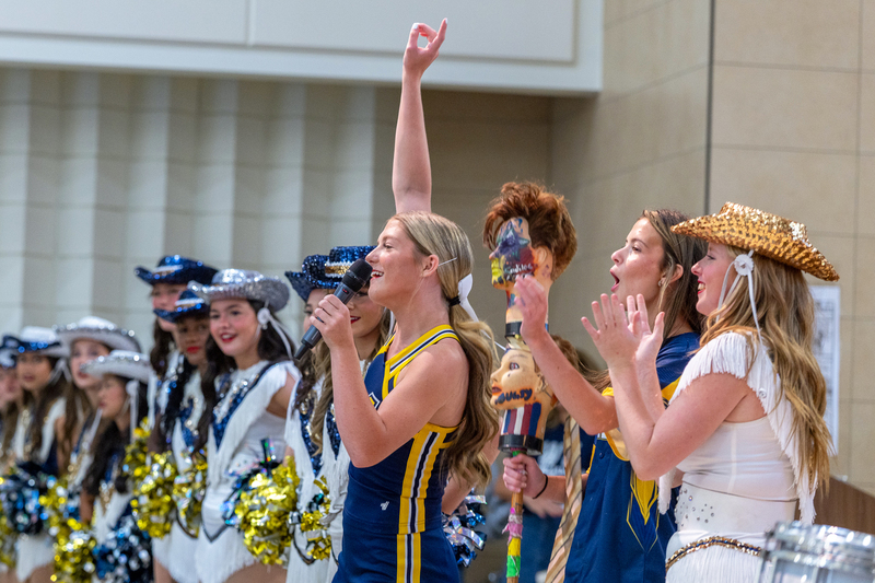 cheer, headhunter and drill team members cheering on stage