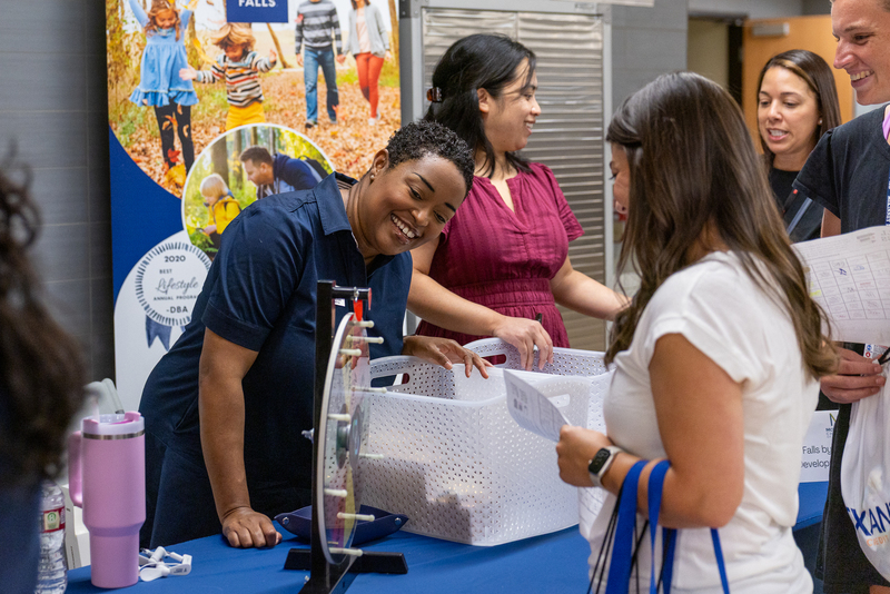 woman at booth smiling and talking to teacher