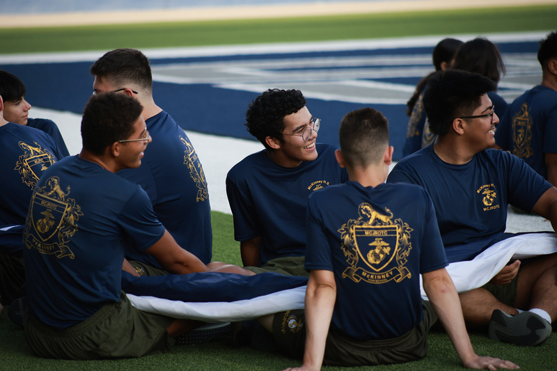 cadets sitting on the ground with flag
