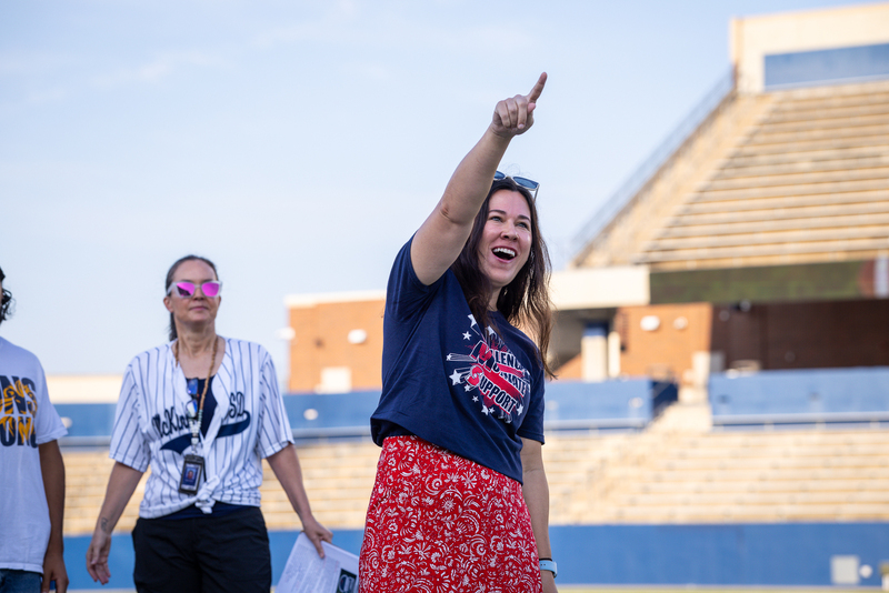 teacher being introduced and pointing to crowd