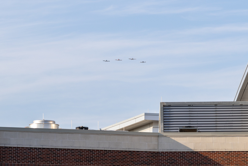formation of student piloted planes approaching stadium