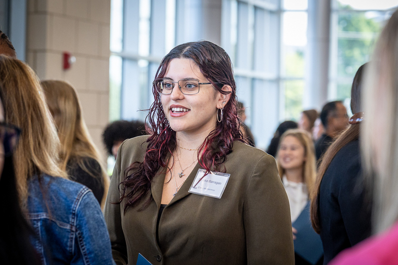 female student talking with other students before the start of the ISM event in the lobby