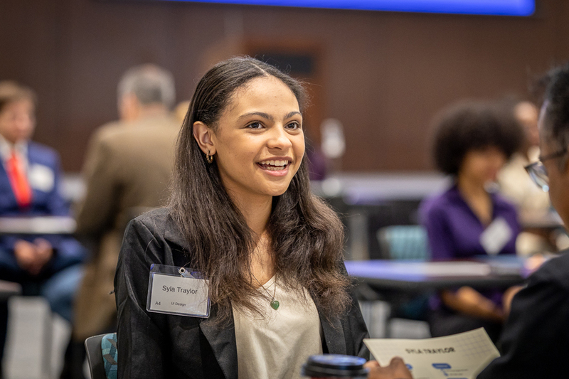 female student smiling at table during interview