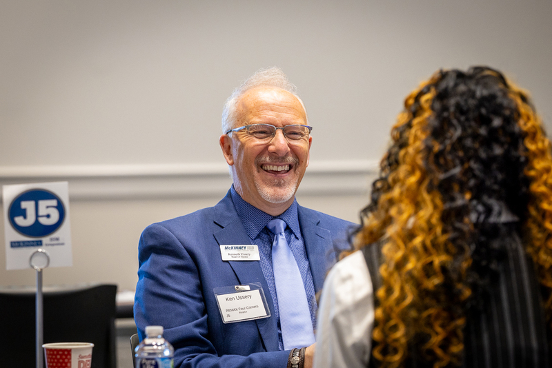Board member Kenneth Ussery laughs during a conversation with a student